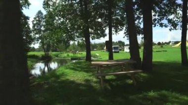 Nehir, tekneler ve piknik alanı. Yaya köprüsünün, küçük nehrin, kamp alanındaki piknik alanının....