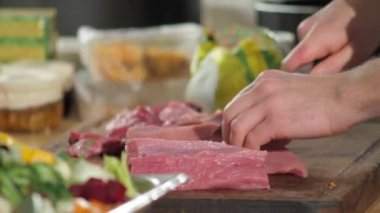 yakın plan çekimde aşçı elleri domuz etini şeritlere ayırıyor.