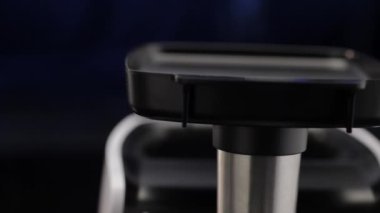 Et öğütücü tepsisi, kadın açılışına et koyuyor, koyu mavi fütüristik arka plan