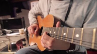Sadece iki teli kalmış, kırık akustik gitar çalan müzisyenlerin el kamerasıyla çekilmiş, blues.