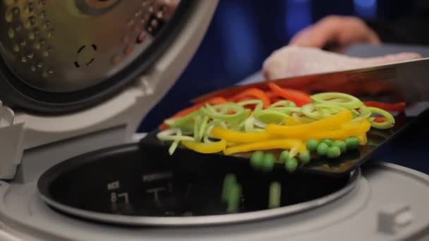 黒いガラス板 エンドウ豆 パプリカ 玉ねぎからナイフで野菜を調理装置に押し込まれています — ストック動画