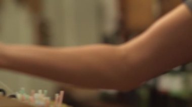 Panoramik takip, bar tezgahına konan bira bardağının yakın plan çekimi, sonra adamın eli onu alır.