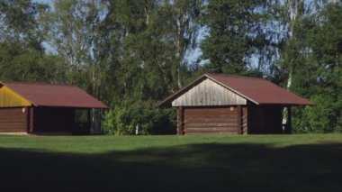 Muhteşem kahverengi kamp kulübelerinin çayırlarında oynayan çocukların geniş açılı görüntüsü.