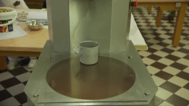 在巧克力工厂的巧克力搅拌机上放一个铝杯的镜头 — 图库视频影像