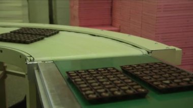 Paketin içindeki çikolataların 90 derecelik açıyla konveyör hattındaki statik yakın çekim görüntüsü.