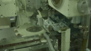 Çikolata ambalaj makinesinin statik makro görüntüsü çikolata fabrikasında çalışıyor.