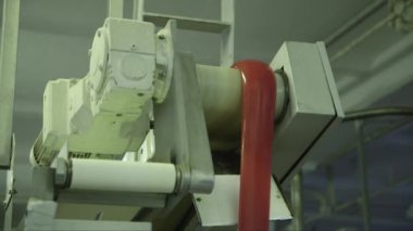 Bir şeker fabrikasında, yumuşak bir karamelin konveyör şeridinin kenarından düşüşünün statik yakın çekimi.