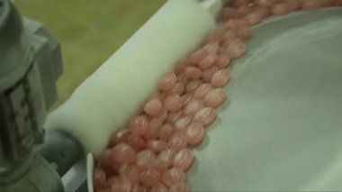 Dağıtıcı diskteki lolipopların beyaz bir fırçayla hız çizgisine girerken yakın çekim görüntüleri.
