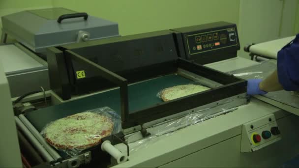 Statyczne Średnie Ujęcie Pracownika Pakującego Pizze Celofanową Maszyną Pakującą Fabryce — Wideo stockowe