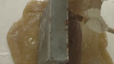 Büyük bir parça karamelin üzerine dökülen çikolatanın yakın çekim görüntüsü ve sonra hamurun yağlanması.