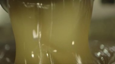 Bir kaseye dökülen esnek bir karamel kütlesinin makro görüntüsü.