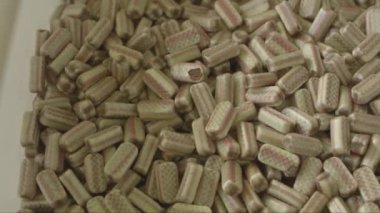 Şeker fabrikasında dev bir yığın bej lolipopun yakın plan çekimleri.