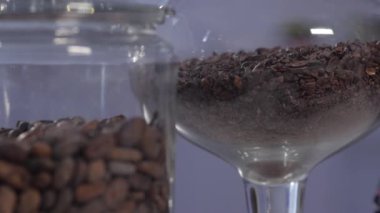 Raflarda ezilmiş makro fotograf ve zarif cam kaplarda kakao çekirdekleri var.