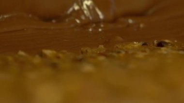 karamelli ve fındıklı sıvı çikolatayla kaplı kütleyi yakın çekim statik yavaş çekim