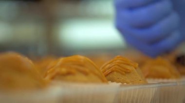 durağan yavaş çekim makro odaklanma hareketi. Pasta şefinin birçok küçük karınca yuvası kekine çikolata kırıntıları serpiştirmesi.