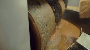 Çikolata karıştırma makinesine öğütücü taşlarla kakao karıştırılırken çekilen ağır çekimde kakao.