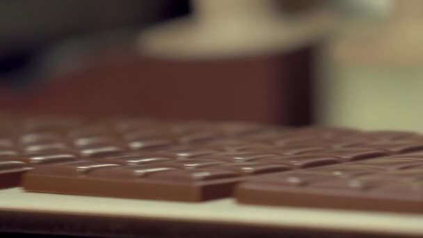 コンベヤー ラインにチョコレート バーを置く吸引機の静的な遅い動きのマクロのショット — ストック動画