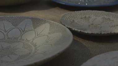 Zanaatkar pazarında hareket eden yeşillik gölgeleriyle yüksek kaliteli renkli kil levhaların yakın plan çekimleri.