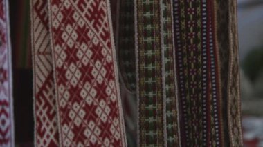 Markette renkli dokuma jartiyer ve bel bantlarının yakın plan çekimleri.