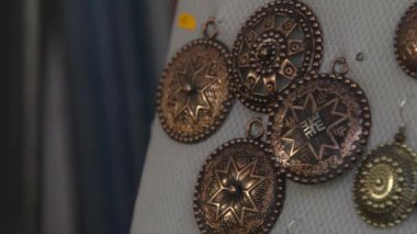 Metal mücevherlerin yakın plan çekimleri, el sanatları pazarında sergilenen küpeler.