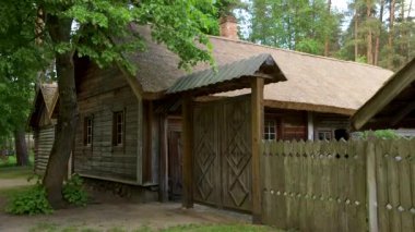 Ormanda tarihi ahşap binalarla dolu bir avlunun geniş açılı görüntüsü.