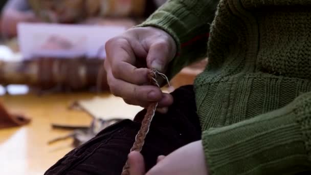 ハンドヘルド閉じる女性の手編みの革編みブレスレットのショット — ストック動画