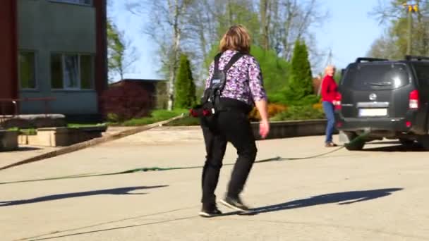 Panning Medium Shot Woman Special Belt Puxando Carro Pelo Cabo — Vídeo de Stock