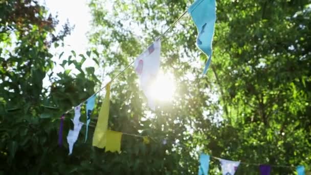 Güneşe Karşı Bahçede Renkli Bayraklar Dizisinin Yakın Çekimi — Stok video
