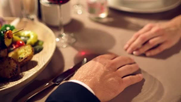 ドリーはシックなレストランのテーブルに女性の手を置く男のショットを閉じます — ストック動画