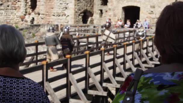 Two Women Watch Staged Battle Medieval Soldiers — Stock Video