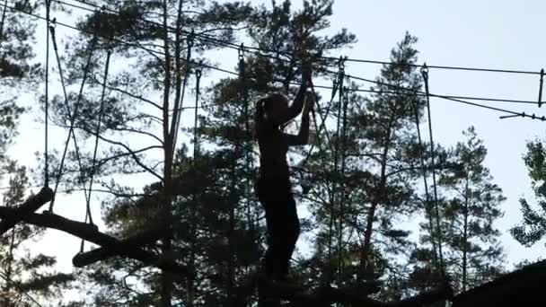 Girl Silhouette Overcomes Tree Obstacle Course — Stock Video