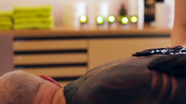 Donna Che Massaggia Schiena Dell Uomo Con Fango Nero Garantito — Video Stock