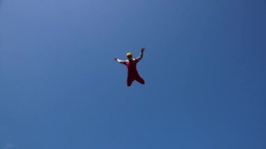 Paraşüt kıyafetli adam dikey rüzgar tünelinin üstündeki havada uçuyor. Dikey Rüzgar Tüneli Ağaçların Üzerinde Uçan Kuş Gibi Mavi Gökyüzünün Altında Deneyime İzin Verir.