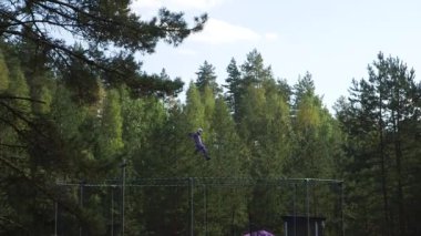 Paraşüt kıyafetli sporcu dikey rüzgar tünelinin üzerinde gösteri yapıyor. Dikey Rüzgar Tüneli Ağaçların Üzerinde Uçan Kuş Gibi Mavi Gökyüzünün Altında Deneyime İzin Verir.