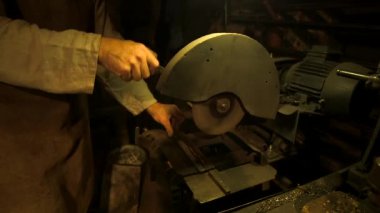 Demirci atölyedeki Demir Kesiciyle Metal Barı Kesiyor. Demirci, öncelikle Demir ya da Çelik 'ten ama bazen de diğer metallerden nesneler yaratan bir demircidir..