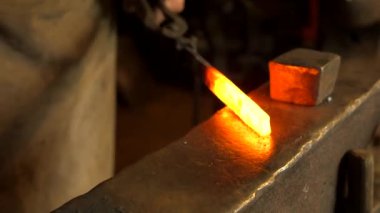 Demirci Anvil 'deki Red Hot Metal Bar' ı dövdü. Demirci, öncelikle Demir ya da Çelik 'ten ama bazen de diğer metallerden nesneler yaratan bir demircidir..