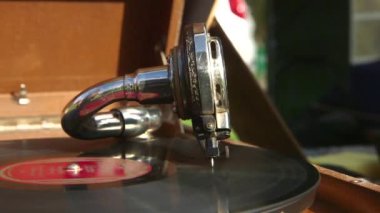 Plak ahşap bir kutuda antik bir gramofonu açıyor. Müzik çalıyormuş. Gramofon müzik çalmak için bir araçtır. Plak Çalıyor - İğne ile güçlendirilmiş Grooves 'lu Vinyls.