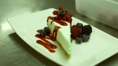 Şef yaban mersinli güzel dekore edilmiş cheesecake 'e sarı çiçek ekler. Cheesecake, yumuşak taze peynirli, tipik olarak Cottage, Cream Quark Cheese, Ricotta, yumurta ve şekerle yapılan bir tatlıdır..