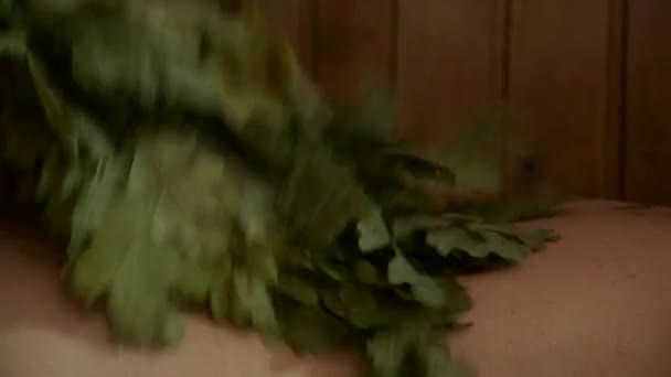Γυμνό Σώμα Γυναίκας Στη Σάουνα Παίρνει Ελαφρά Χτυπημένο Φύλλα Δέντρου — Αρχείο Βίντεο