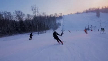 Kayakçı tepeden aşağı gidiyor. Birkaç kayakçı daha geçiyor. Yeterli Alan ve Görüş Alanı varsa Bir Kayakçı veya Snowboardcu Başka Bir Kayakçıyı Geçebilir.