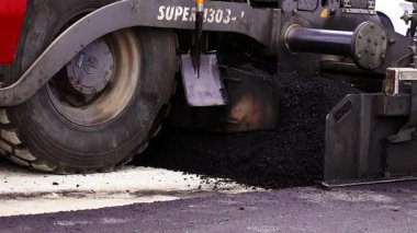 Asfalt Paving Makinesi çalışıyor. Graded Gravel Asfalt 'ın üzerine dök. Road Paver Finisher, Asfalt Bitirici, Road Paving Machine, asfalt betonu sermek için kullanılan bir yapı ekipmanıdır..