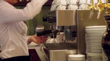 Barista bir barda profesyonel kahve makinesiyle kahve yapıyor. Barista, barmen bir kişidir, genellikle Espresso 'yu hazırlayan ve servis eden bir kafe çalışanıdır..