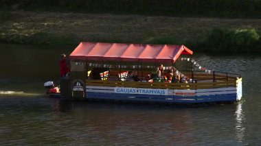 Küçük Renkli Turist Teknesi - Raft, Sonbaharda nehir boyunca yelken açıyor. Valmiera, Hanseatik Birliği üyesi olarak Letonya 'nın en eski şehirlerinden biridir..