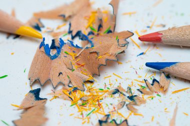 Beyaz arkaplan üzerinde talaşı olan suluboya kalemler.