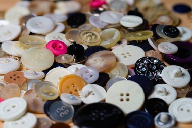 Masaya yayılmış çeşitli dikiş düğmeleri koleksiyonu.
