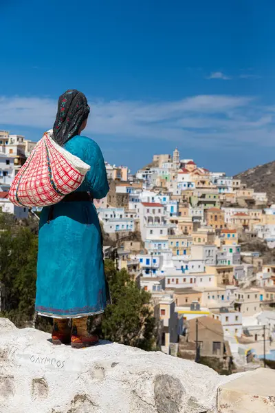 Yunan kadın heykeli geleneksel bir kıyafetle Olympmpos, Karpathos, Yunanistan 'a bakıyor.
