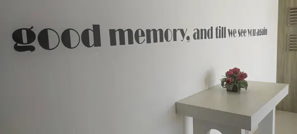 Inspirational quote on the wall with white table and flower vase interior decoration in the corner