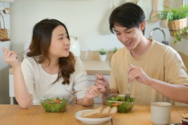 Bir adam ve kadın mutfakta birlikte yemek yiyorlar...