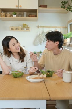 Bir adam ve kadın mutfakta birlikte yemek yiyorlar...