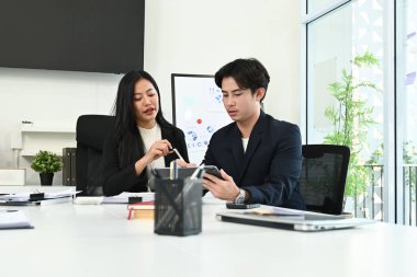 Çalışma masasında bilgisayar ve dijital tabletle birlikte çalışan genç ofis çalışanlarının fotoğrafı...